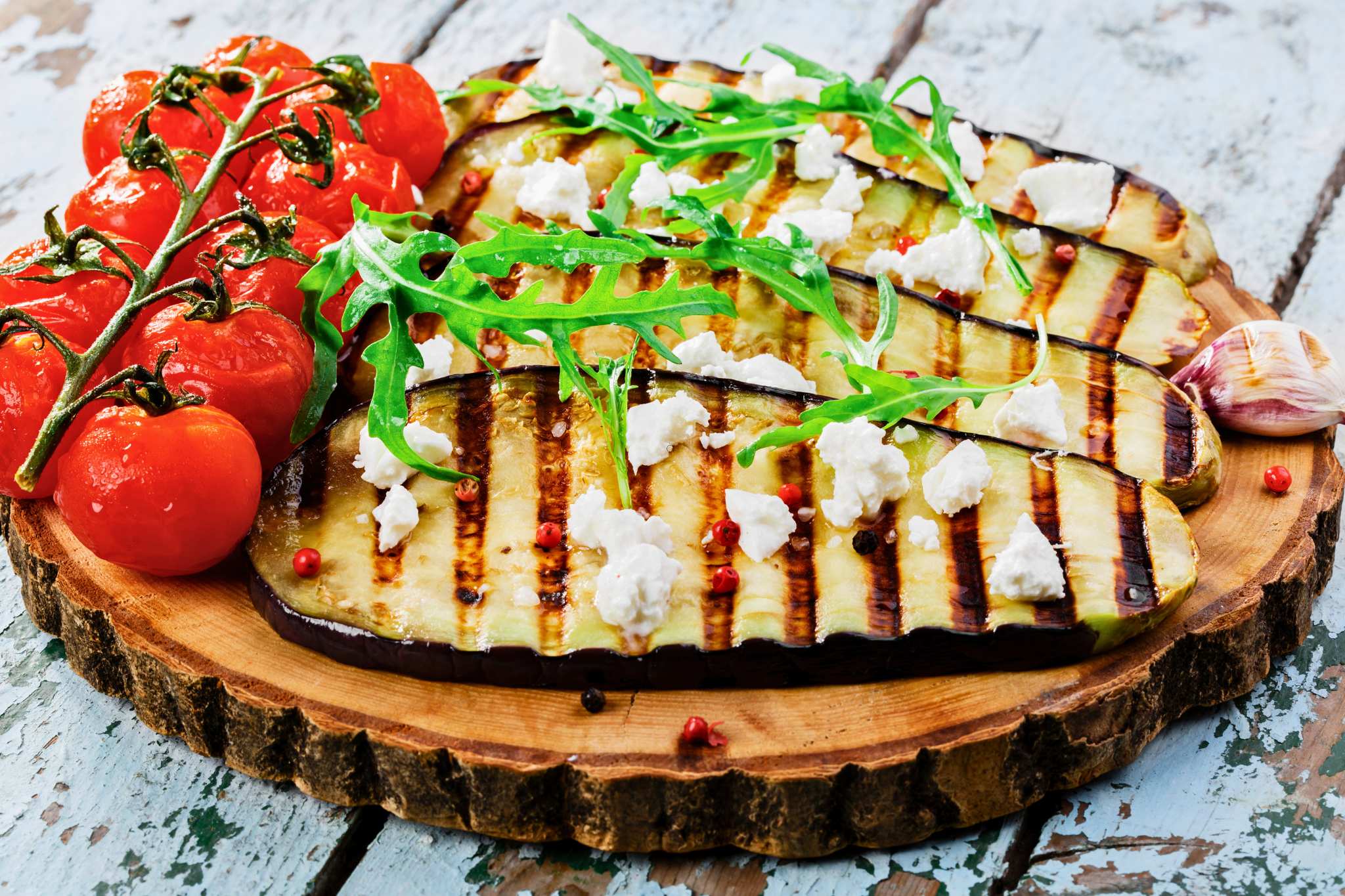 Berenjenas a la plancha con queso en un plato de madera