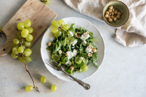 Ensalada de rúcula, uva, queso de cabra y avellanas