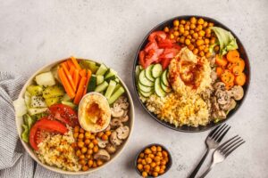 Buddha bowl con quinoa, hummus de garbanzos, berenjena y calabacines asados