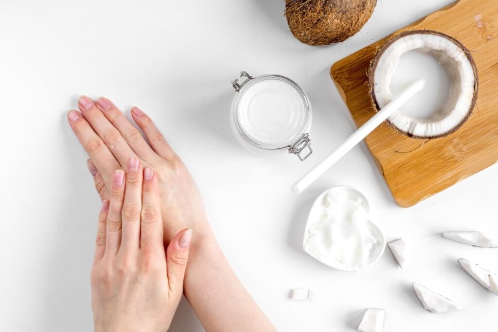 Mujer usa aceite de coco como crema hidratante para las manos