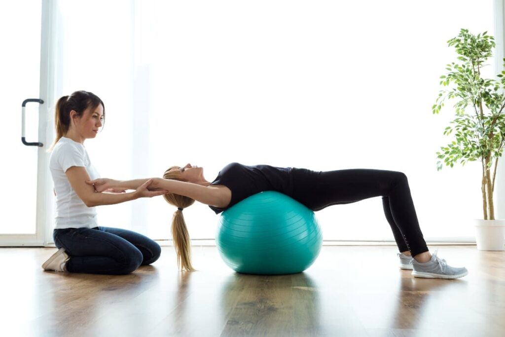 Mujer realiza ejercicios de gimnasia postural con una pelota