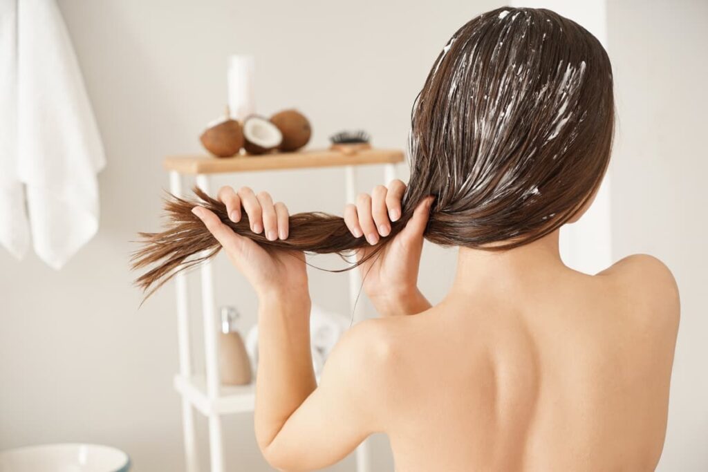 Mujer utiliza una mascarilla para el cabello encrespado después del champú