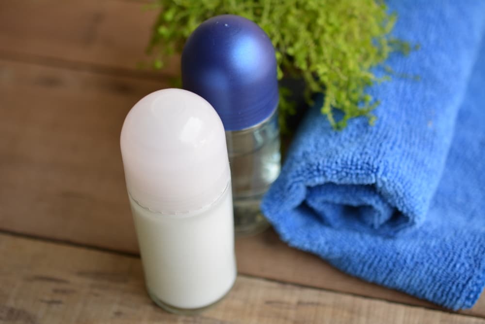 Dos desodorantes sobre una mesa muy útiles cuando se quiere aprender a cómo sudar menos en verano