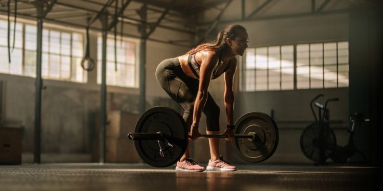 Mujer hace peso muerto en un gimnasio